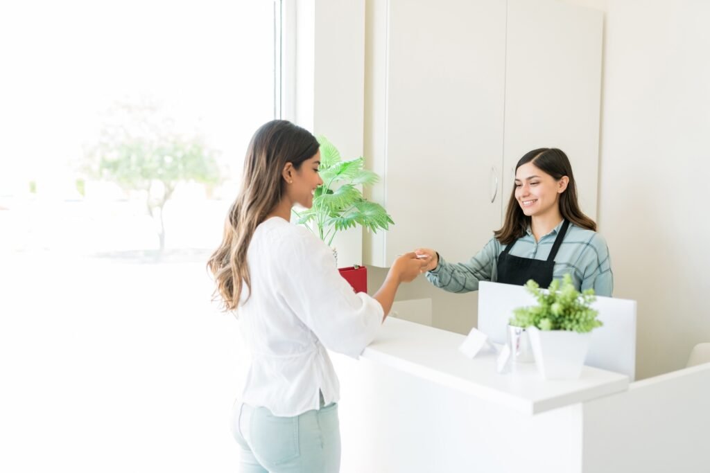 Satisfied Client Paying At Reception Desk In Spa